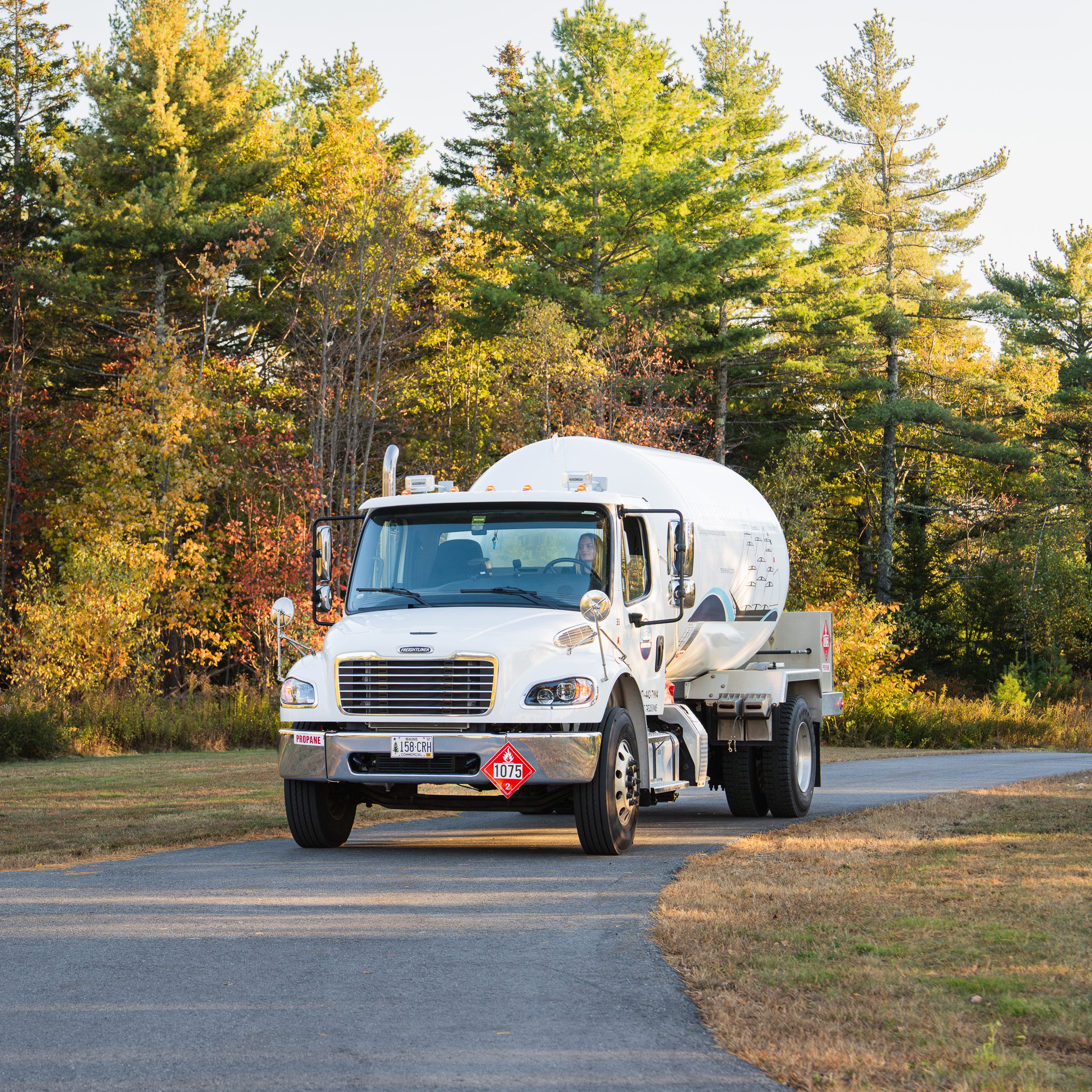 Prompt, professional fuel delivery you can count on, right to your door. A professional propane delivery truck pulling into a residential driveway for a scheduled fuel refill.